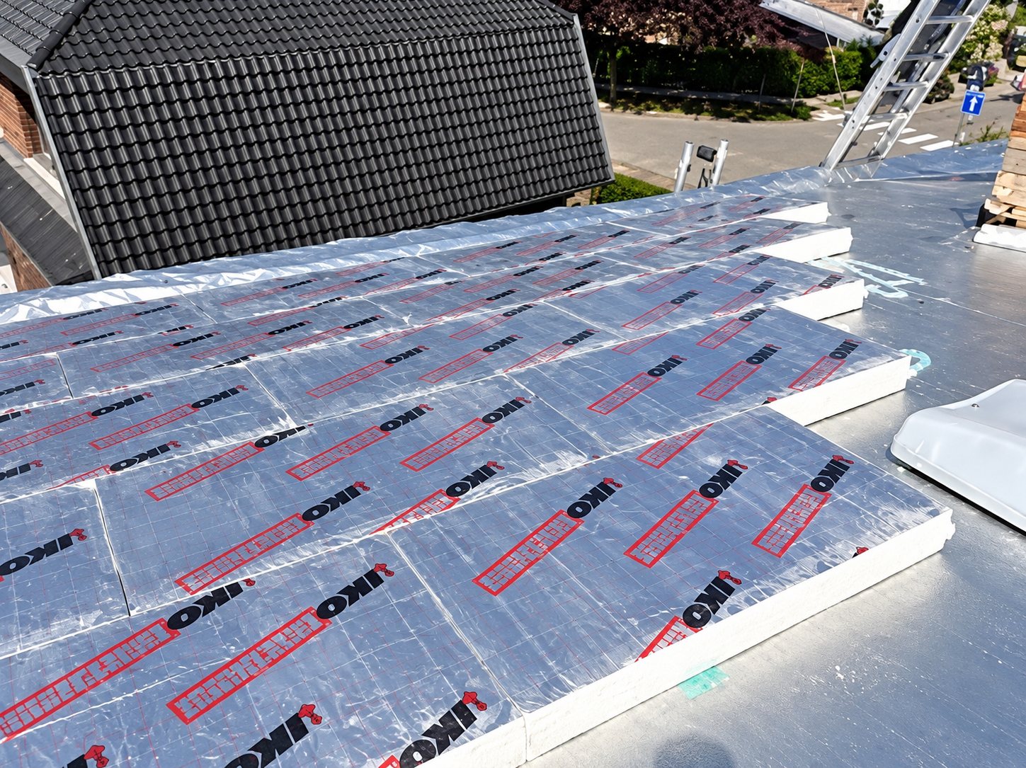 Panneaux isolants à parement réfléchissant posés sur un toit plat en rénovation
